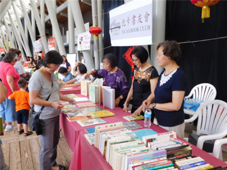 北卡書友會(huì)為游客寫書法和義賣中英文書籍,。(美國(guó)《世界日?qǐng)?bào)》/王明心 攝) 北卡書友會(huì)為游客寫書法和義賣中英文書籍,。(美國(guó)《世界日?qǐng)?bào)》/王明心 攝)