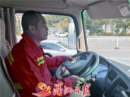 圖為灑水車司機(jī)張國慶在馬路上灑水作業(yè),。 圖為灑水車司機(jī)張國慶在馬路上灑水作業(yè),。
