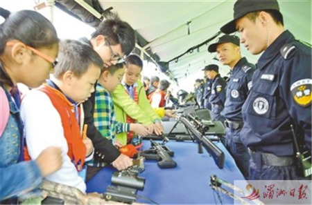 日前,，市公安局舉行警營開放日,，邀請各界群眾代表走進警營，體驗警營生活,、了解公安工作,，進一步促進警民關(guān)系,。圖為部分學(xué)生代表正在了解槍械知識。 記者 吳偉鋒 攝