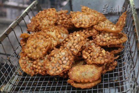 花生餅從油鍋中撈上來,，呈金麥色的色澤,。（馬來西亞《星洲日報(bào)》）