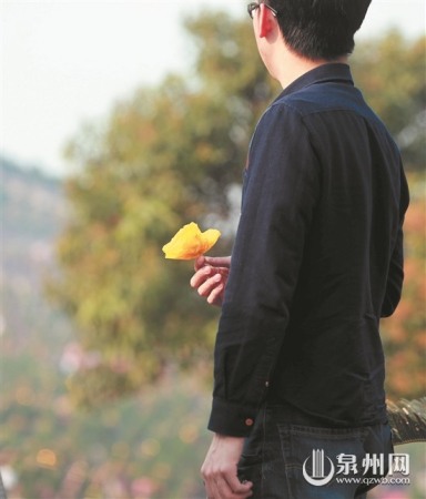 泉州宏福園,,一位市民拿著黃色紙菊花準(zhǔn)備祭拜逝者,。(潘登/攝) 泉州宏福園,,一位市民拿著黃色紙菊花準(zhǔn)備祭拜逝者。(潘登/攝)