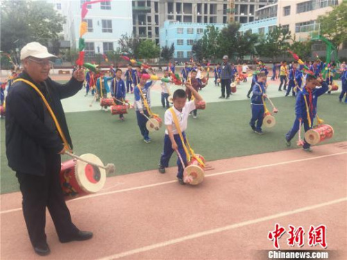 魏永宏一板一眼地指導(dǎo)孩子們打鼓的每個動作?！∈缝o靜 攝