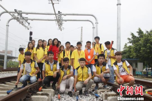 華裔青少年在軌道上合影,?!≈炝?攝 華裔青少年在軌道上合影,。 朱柳融 攝