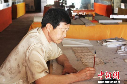 在甘肅敦煌市的一處民俗旅游地——月牙泉小鎮(zhèn)內(nèi),,傅有宏伏案臨摹敦煌漢簡,。 徐雪 攝 在甘肅敦煌市的一處民俗旅游地——月牙泉小鎮(zhèn)內(nèi),,傅有宏伏案臨摹敦煌漢簡?!⌒煅?攝