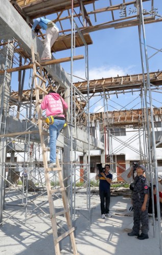 在建筑工地工作的外勞，從建筑中的屋宇樓上爬梯子下樓接受調(diào)查,。(馬來西亞《星洲日報》)