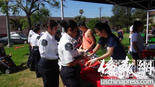 華裔女孩在史密斯公園做義工，為參加“兒童日”活動的青少年提供免費午餐,。（美國《僑報》/高睿 攝）