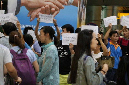 進行糾察的導(dǎo)游們高舉手卡,，抗議本地旅行團雇用無牌中國導(dǎo)游。（馬來西亞《星洲日報》）