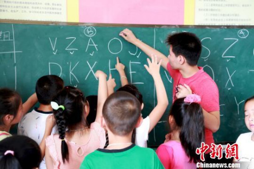 圖為美國(guó)華裔少年為當(dāng)?shù)睾⒆觽兘淌谟⒄Z,。 陳水蓮 攝 圖為美國(guó)華裔少年為當(dāng)?shù)睾⒆觽兘淌谟⒄Z?!£愃?攝