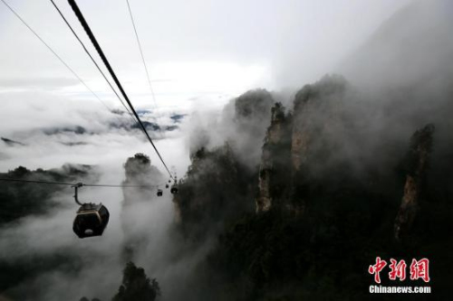 10月5日，“十一”國慶假期的第五天,，雨中的湖南張家界武陵源風(fēng)景區(qū)現(xiàn)云霧景觀,，山峰被隨風(fēng)飄舞的云霧所纏繞，宛若一幅水墨畫,。來自武陵源區(qū)旅工委辦公室的消息稱,，目前武陵源各景區(qū)接待正常，秩序井然,。 吳勇兵 攝