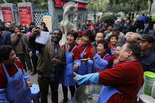 圖7:2015年農(nóng)歷二月初二,當(dāng)日來紅日亭吃芥菜飯的路人很多,,溫州醫(yī)學(xué)院留學(xué)生艾鵬達(dá)聞訊后來紅日亭當(dāng)義工,。在場的紅日亭老人們紛紛與艾鵬達(dá)開心留影。 圖7:2015年農(nóng)歷二月初二,,當(dāng)日來紅日亭吃芥菜飯的路人很多,溫州醫(yī)學(xué)院留學(xué)生艾鵬達(dá)聞訊后來紅日亭當(dāng)義工,。在場的紅日亭老人們紛紛與艾鵬達(dá)開心留影,。