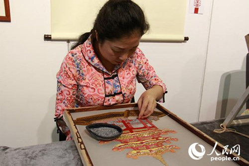 潮汕刺繡項(xiàng)目傳承人洪裕靜借鑒了雙面繡技法，正在進(jìn)行雙面珠繡的創(chuàng)作,。(攝影：吳玉潔)