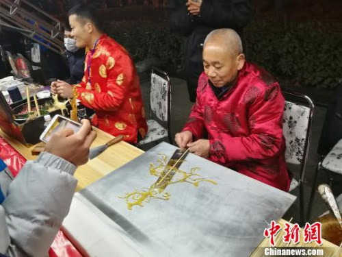 圖為非遺傳承人在制作唐人,。 董飛 攝 圖為非遺傳承人在制作唐人?!《w 攝