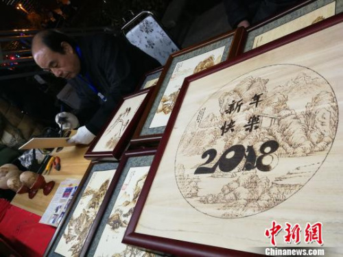 圖為非遺傳承人在制作烙畫,?!《w 攝 圖為非遺傳承人在制作烙畫,。 董飛 攝
