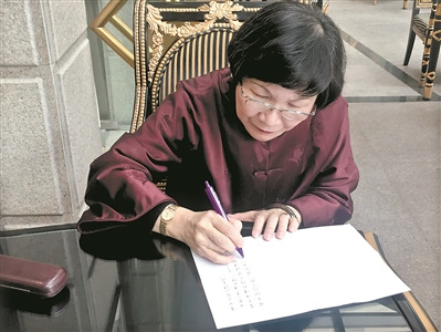 周功鑫在給廣州日報讀者寫寄語,。 周功鑫在給廣州日報讀者寫寄語,。