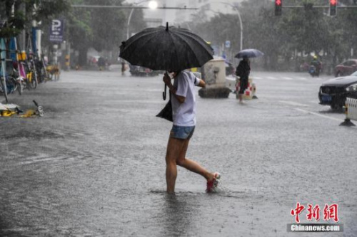 資料圖:??诿癖娒坝晟嫠鲂小q樤骑w 攝 資料圖:海口民眾冒雨涉水出行,。駱云飛 攝