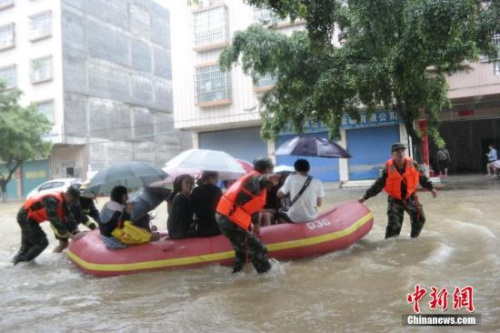 資料圖：臺(tái)風(fēng)“艾云尼”6月7日晚登陸廣東陽(yáng)江海陵島，造成持續(xù)大暴雨到特大暴雨,，8日武警用沖鋒舟將考生安全送至考場(chǎng),。 <a target='_blank' >中新社</a>發(fā) 楊璐 攝