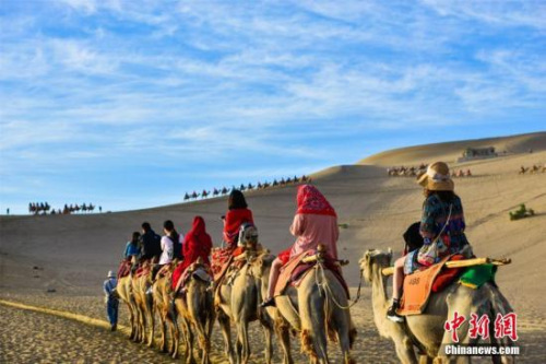 資料圖：絲綢之路國際旅游名城甘肅敦煌,，鳴沙山月牙泉人流如織,、駝隊(duì)如龍,。王斌銀 攝