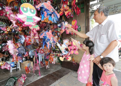 羅進(jìn)錫每年中秋節(jié),，都會(huì)帶著孫女到商店選購喜愛的燈籠,。（馬來西亞《星洲日?qǐng)?bào)》）