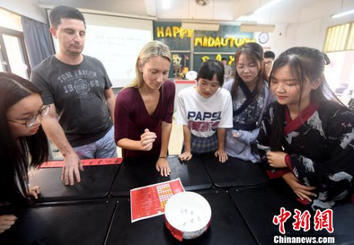 圖為外籍教師在體驗“博餅”游戲,?!埍蟆z 圖為外籍教師在體驗“博餅”游戲,。 張斌 攝