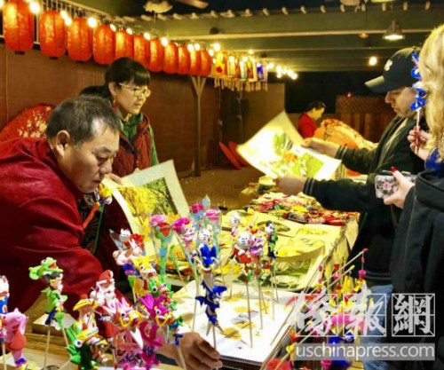 游客對中國傳統(tǒng)藝術(shù)刺繡和泥塑人偶充滿興趣,。(美國《僑報》/翁羽 攝) 