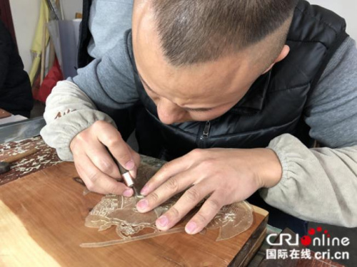 皮影匠人用華州皮影獨一無二的“推皮走刀法”雕刻。攝影:張捷 皮影匠人用華州皮影獨一無二的“推皮走刀法”雕刻,。攝影:張捷