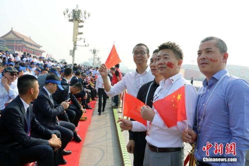 10月1日,，慶祝中華人民共和國成立70周年大會在北京隆重舉行,。約2000名海外華僑華人在現(xiàn)場見證了歷史時刻。他們表示,，國慶慶典展現(xiàn)了中華民族的自信和威嚴(yán),，凝聚起了全球僑胞的心。圖為來自巴布亞新幾內(nèi)亞的薛輝雄等在觀禮臺合影,。<a target='_blank' >中新社</a>記者 任海霞 攝