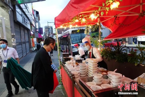 資料圖：當?shù)貢r間8月16日晚,，一家中餐廳在紐約法拉盛社區(qū)街道旁外賣菜肴。隨著紐約經(jīng)濟活動的恢復,，當?shù)孛癖娨归g活動逐漸增多,。<a target='_blank' >中新社</a>記者 廖攀 攝