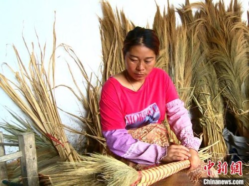 圖為允哈村村民正在編制掃帚,。昆明海關(guān)供圖