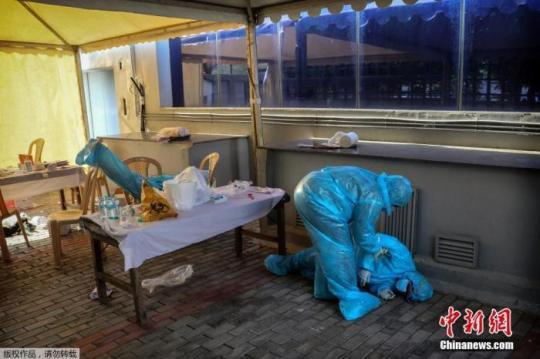 資料圖：印度新德里的核酸監(jiān)測點(diǎn),，一名衛(wèi)生工作者因疲勞過度倒下,。Manish Swarup