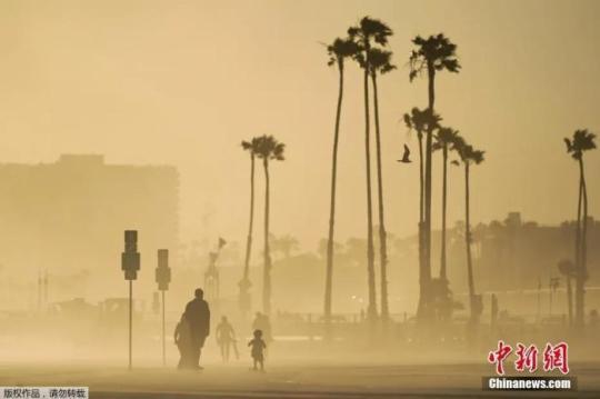 當(dāng)?shù)貢r(shí)間4月18日，美國加州海邊大風(fēng)卷起沙土,，游客在漫天黃沙中出行,。