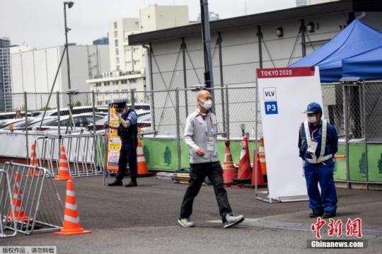 圖為東京2020年奧運會的一名參賽者通過安保人員走出東京奧運村和殘奧會村,。