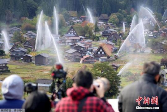 資料圖：位于日本岐阜縣白川村的白川鄉(xiāng)合掌造村落舉行放水演習,，引來眾多游客圍觀,。