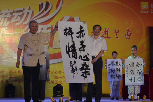 原紹興市委副書(shū)記、紹興市書(shū)法協(xié)會(huì)會(huì)長(zhǎng)袁長(zhǎng)壽(左)當(dāng)場(chǎng)書(shū)寫(xiě)《赤子心桑梓情》贈(zèng)與省僑聯(lián),。