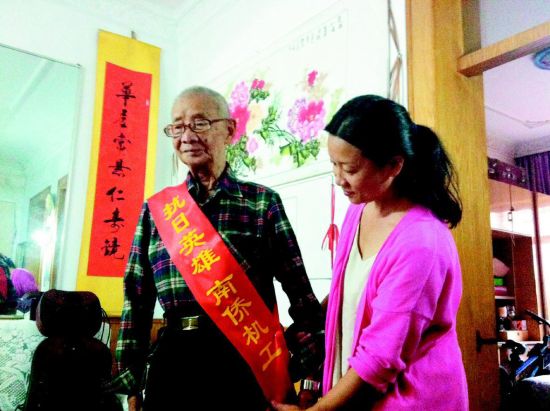 中國僑網女兒蘇小紅為老人整理綬帶,。(《太原晚報》/裴怡 攝)