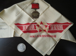 中國(guó)僑網(wǎng)周祝令珍藏60多年的3件紀(jì)念品:一枚抗美援朝紀(jì)念章,、一方“抗美援朝、保家衛(wèi)國(guó)”手帕和一塊救命銀元,。(《青田僑報(bào)》)