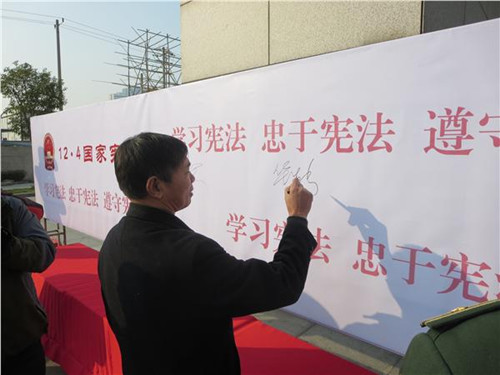 中國(guó)僑網(wǎng)市僑辦華生新副主任在遵守憲法,、法律承諾墻上簽名