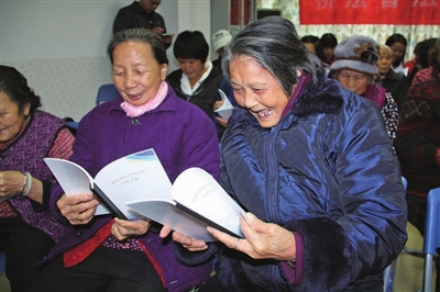中國(guó)僑網(wǎng)大鵬新區(qū)居民開心翻看僑法宣傳手冊(cè),。(《深圳僑報(bào)》/林琳 攝)