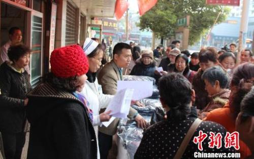 中國僑網(wǎng)發(fā)放大衣,。(秦玉平 攝)