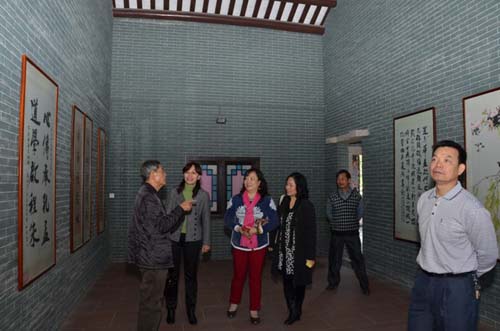 中國(guó)僑網(wǎng)廣州市僑辦副主任唐憶春參觀南村村民書畫室。