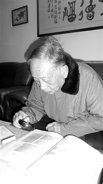 中國僑網張慶培拿著放大鏡閱讀93年前其父張葆琮的信件。(《梅州日報》/曾秋玲 攝)