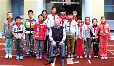 中國僑網(wǎng)周克信老人與龍背小學(xué)的孩子們在一起合影留念。