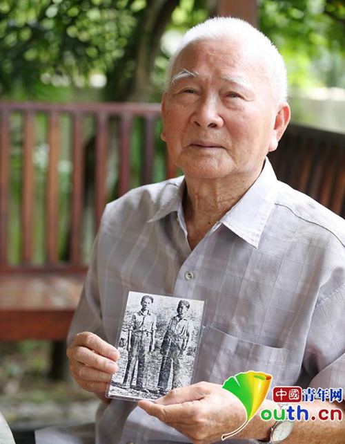 86歲的王聲手拿13歲時(shí)參加抗日遠(yuǎn)征軍的照片(左側(cè)為其本人),向記者講述少年參軍抗日的烽火歲月,。中國(guó)青年網(wǎng)記者