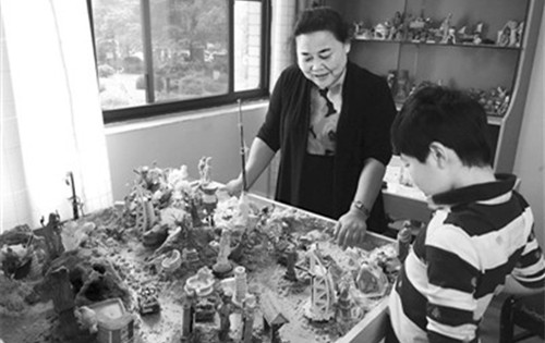 在長沙西湖社區(qū)辦公樓內(nèi)的金老師工作室,,僑眷金利君正在用“沙盤療法”為社區(qū)里的孩子做心理咨詢。