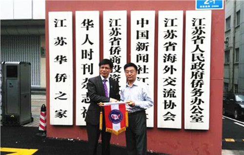 美國中餐聯(lián)盟主席朱天活向江蘇省僑辦副主任孫彬贈送美國中餐聯(lián)盟會旗,。