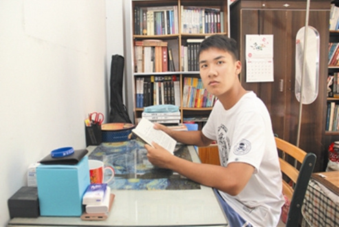 禤德宇在書桌前讀書。