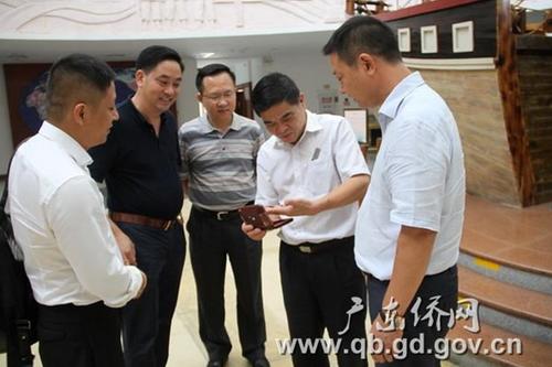 中國(guó)僑網(wǎng)鄭建民副主任(中)、廣東華僑博物館館長(zhǎng)王明惠(右二)與朱金亮?xí)L(zhǎng)(右一)等仔細(xì)研看收藏品