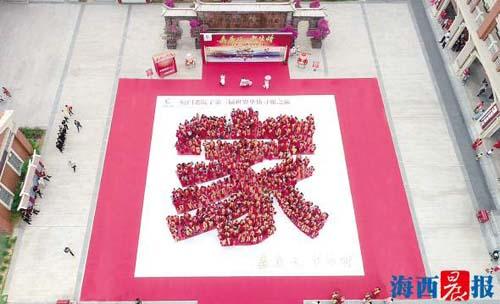 中國(guó)僑網(wǎng)華僑們身穿傳統(tǒng)大紅色漢服,,擺出“家”字。