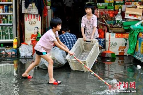 中國僑網(wǎng)資料圖:9月3日,,廣東汕頭市瓦窯村,,兩名女孩協(xié)助家長清理商鋪外的積水。當(dāng)日,,廣東汕頭市潮南區(qū)天氣轉(zhuǎn)好,,內(nèi)澇地區(qū)積水水位逐漸下降。中新社記者 陳驥旻 攝