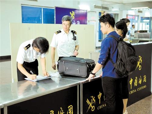 中國僑網(wǎng)海關關員在檢查進境旅客行李物品,。