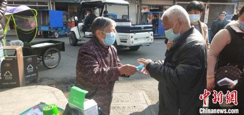 中國僑網(wǎng)徐仙花向過往人群免費(fèi)發(fā)放口罩,。玉壺華僑事務(wù)辦供圖